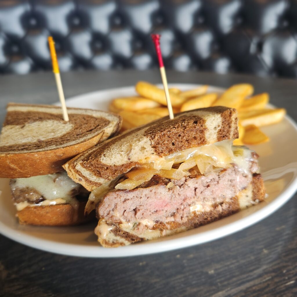 Patty Melt: ½ pound hand pressed ground sirloin patty, topped with sautéed onions, Swiss cheese, served on a marble rye bread drizzled with Thousand Island dressing, served with steak fries.