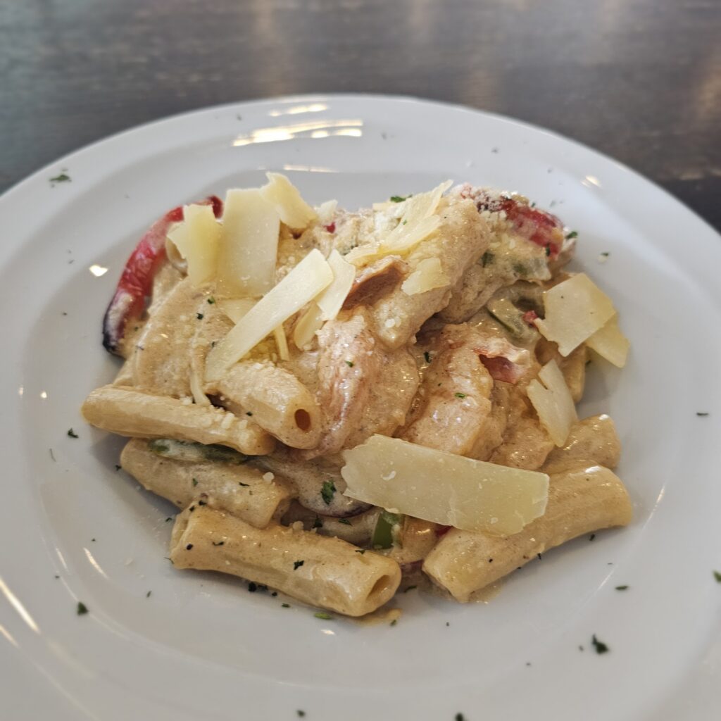 Jambalaya Sauté: Tender chicken, jumbo shrimp & kielbasa, sautéed with peppers, onions, garlic, lemon, and Cajun spices tossed with fresh rigatoni pasta in our savory jambalaya sauce topped with parmesan cheese.