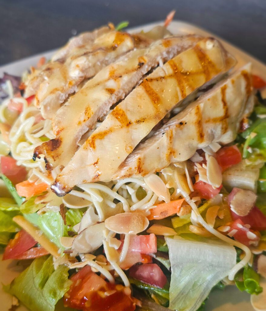Honey Chicken Almond Salad: Mixed greens & romaine tossed in our homemade honey mustard dressing with carrots, tomatoes, crispy wonton strips; topped with angel hair pasta drizzled with sesame oil, grilled honey mustard chicken, & toasted almonds.